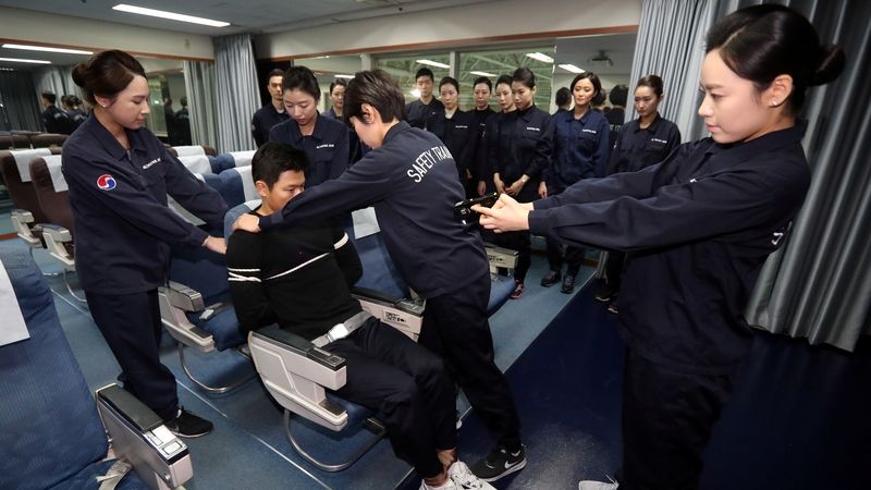 Posádka Korean Air nacvičuje zvládnutí výtržníka na palubě.