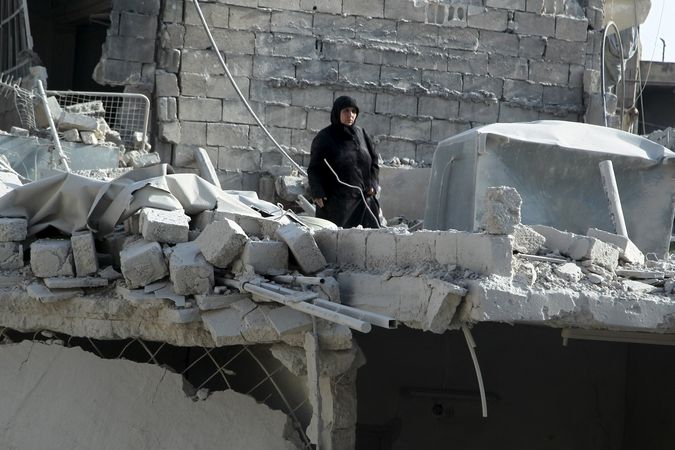 Syřanka si prohlíží škoda po náletu na předměstí Halabu 