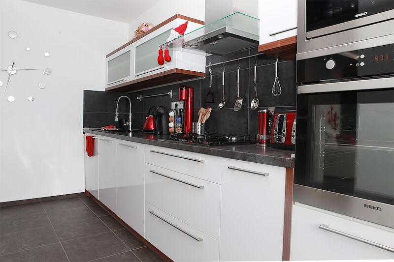 V moderně vybavené kuchyni obzvláště pěkně vynikají červené detaily.