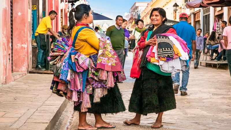 Ženy prodávající pestrobarevné oblečení v ulicích města San Cristóbal de las Casas.