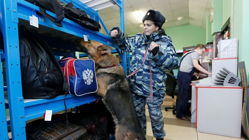Ruská policistka s čuchacím psem kontroluje zavazadla v úschovně na nádraží v ruském Krasnojarsku.  