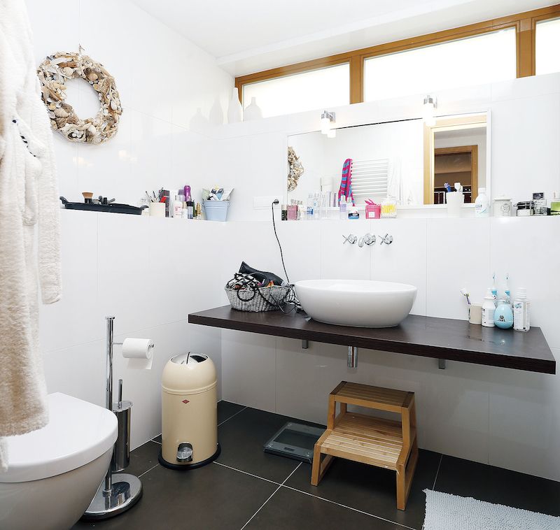 Koupelna je řešena v nadčasové bílé barvě v kombinaci s dřevem. Příjemný je přísun denního světla a vzduchu.