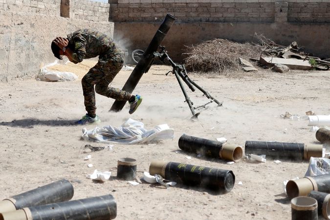 Kurdský milicionář z YPG pálí ze 120 mm minometu na Rakku 