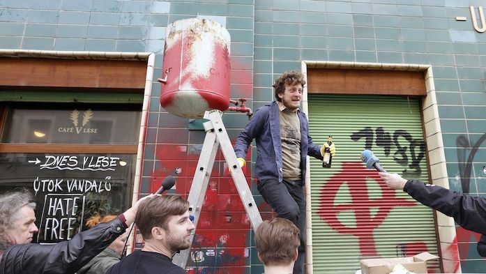 Happening z 25. dubna tohoto roku, během něhož se čistila fasáda pražského Café V lese po nočním útoku vandalů. Ti kavárnu Ondřeje Kobzy (na snímku) pomalovali, podobně jako další tzv. HateFree zóny, nacistickými symboly.