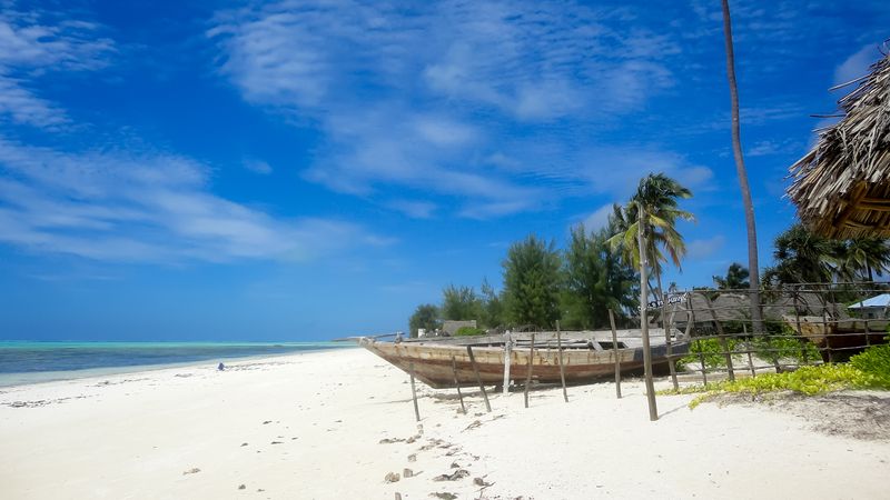Průhledné modrozelené moře, bílý písek a modré nebe, to je Zanzibar.
