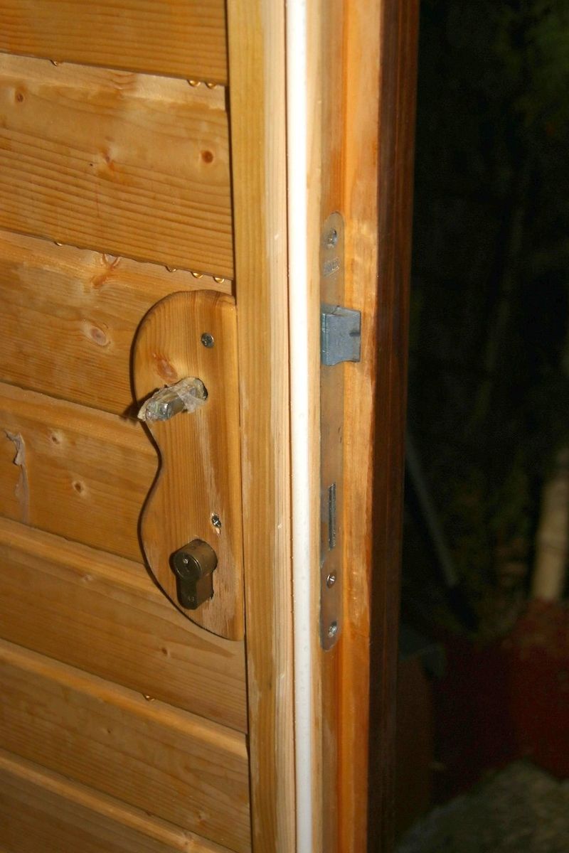 Detail ulomené kliky ve dveřích sauny.