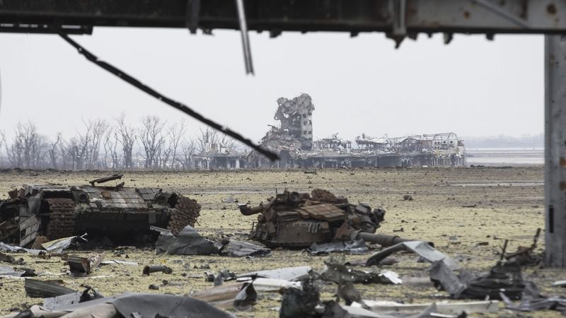 Vraky ukrajinských obrněnců u doněckého letiště, u něhož se opět střílelo.