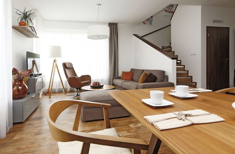 Pohodlná sedačka a televizní stěna navazují materiálově i barevně na kuchyňský kout.