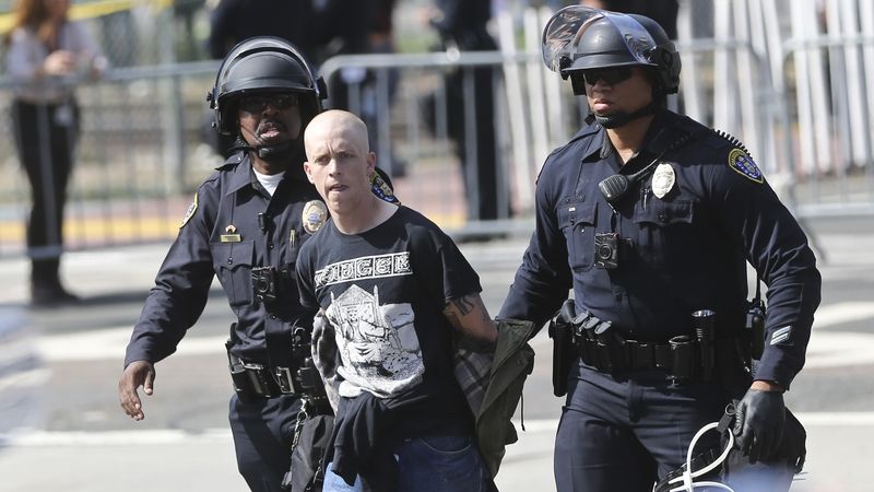 Policie odvádí jednoho z demonstrantlů proti Donaldu Trumpovi