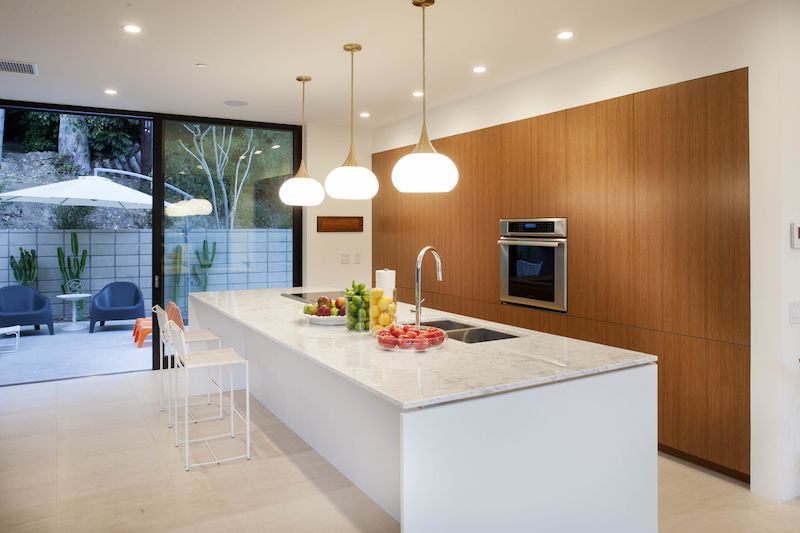 Rozměrný kuchyňský ostrůvek s mramorovou pracovní deskou je přirozeným přechodem mezi kuchyňskou a jídelní zónou.
