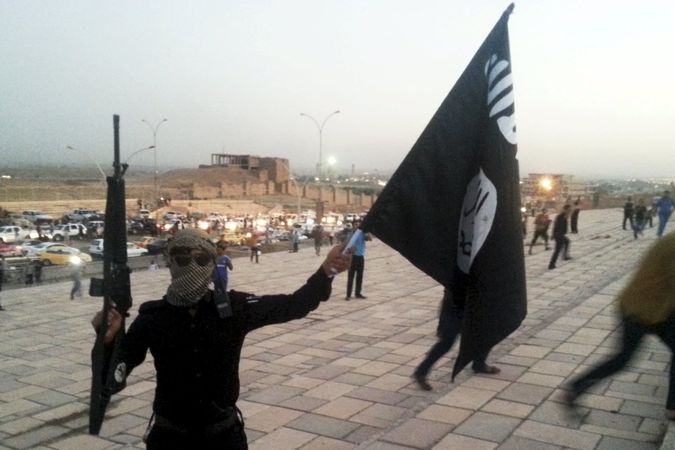 Bojovník Islámského státu s vlajkou v Mosulu 