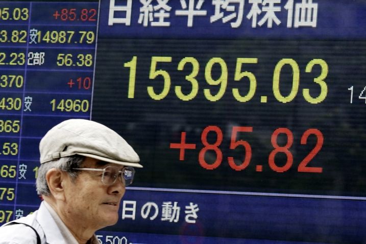 Japonec míjí elektronickou tabuli ukazující růst indexu Nikkei 