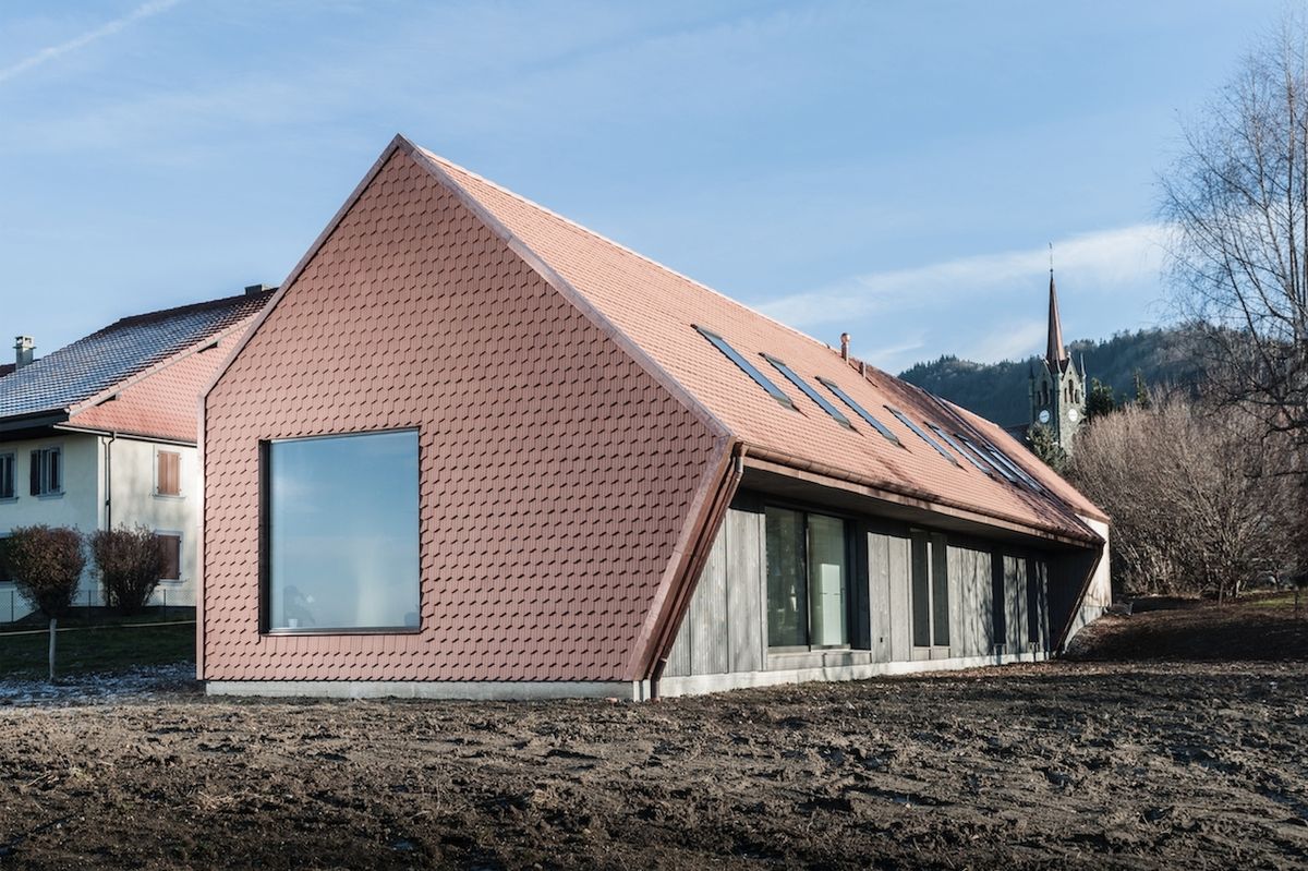 Dům se svým vzhledem přizpůsobuje okolní zástavbě poctivým použitím sedlové střechy a skládané střešní krytiny z pálených tašek.