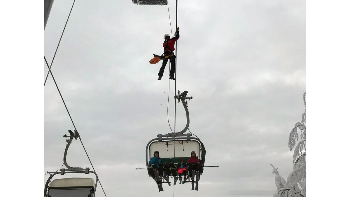 Člen Horské služby slaňuje k lyžařům na sedačkové lanovce v Červené Vodě na Orlickoústecku, kde po pádu stromu zůstalo uvězněno 17. ledna 2019 71 lidí.