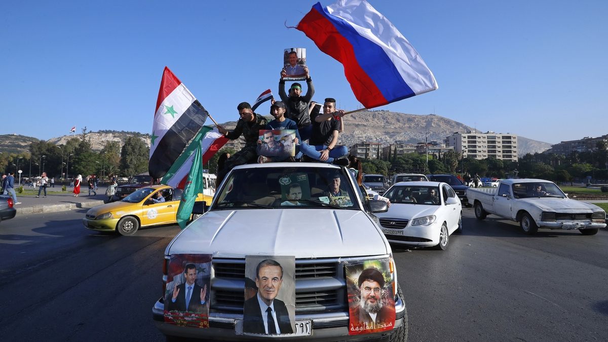Provládní syrští demonstranti se syrskými a ruskými vlajkami v ulicích Damašku