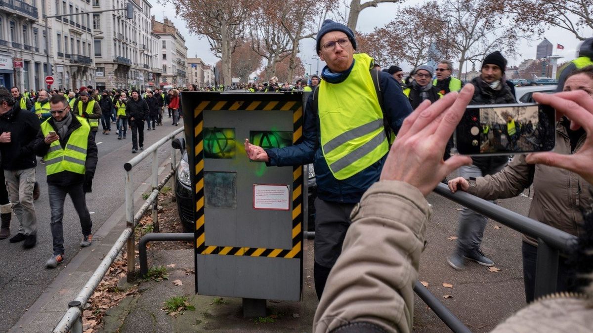 Demonstrant z hnutí žlutých vest před poškozeným radarem v Lyonu