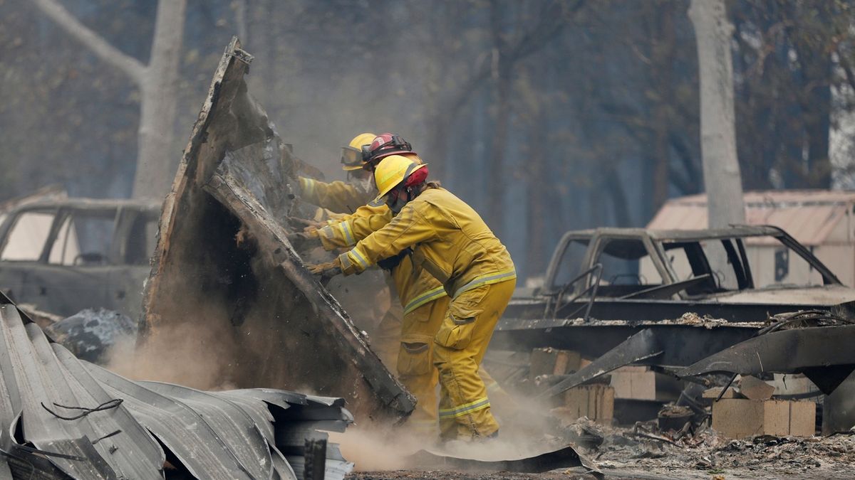 Hasiči u domu zničeného požárem v kalifornském Paradise.