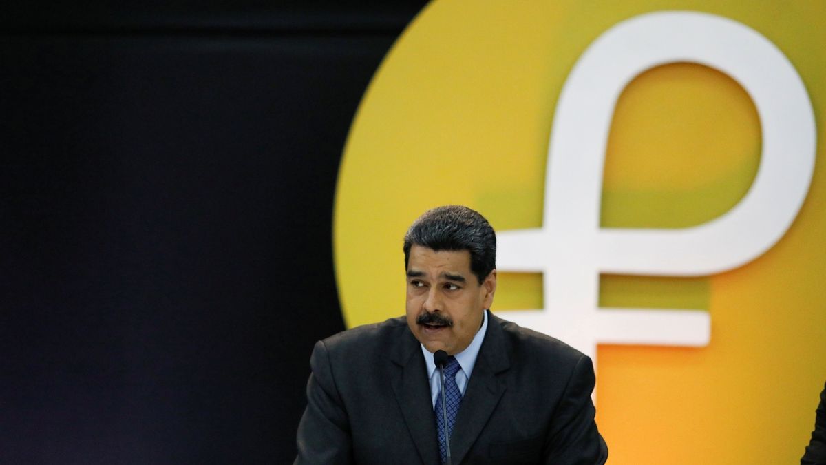 Venezuelský prezident Nicolás Maduro, na pozadí je logo kybernetické měny petro.
