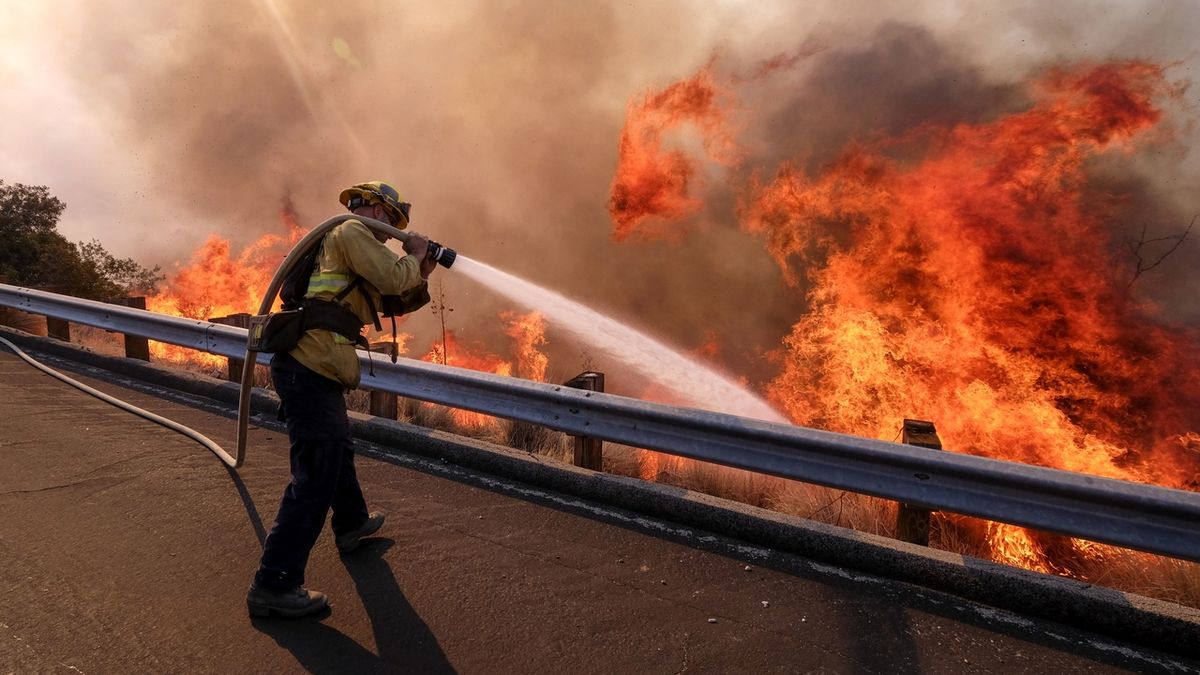 Hasič bojuje s plameny v kalifornském Simi Valley.