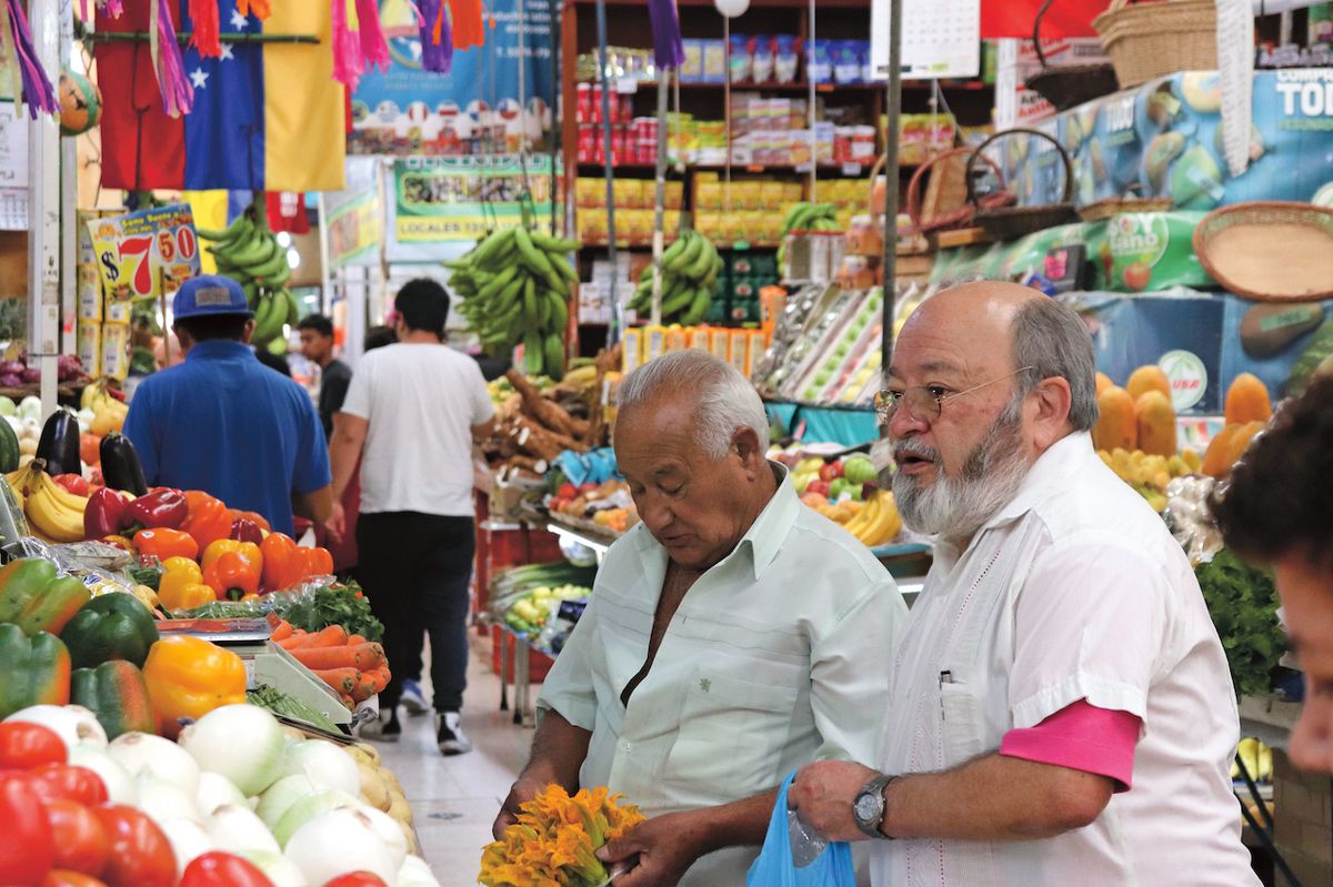 Muži nakupují na trhu v Mexico City. Čerstvé zeleniny a ovoce je tu nepřeberné množství.