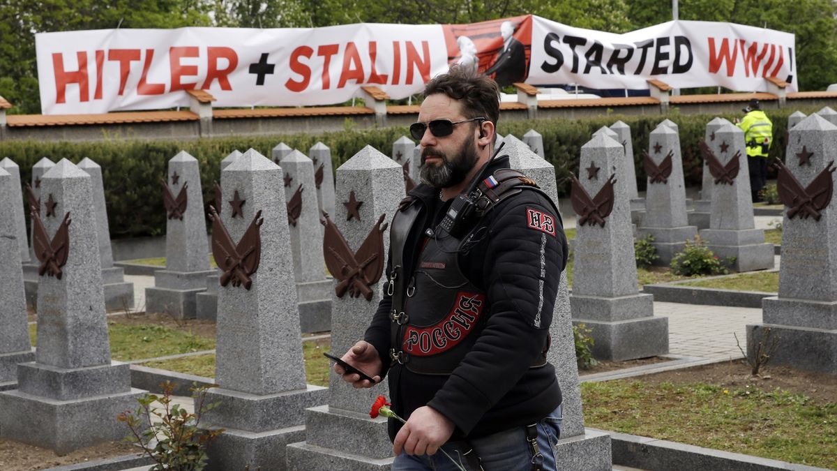 Člen ruského motorkářského klubu Noční vlci na Olšanských hřbitovech v Praze. Za zdí visí nápis, že Hitler se Stalinem stojí za začátkem druhé světové války.