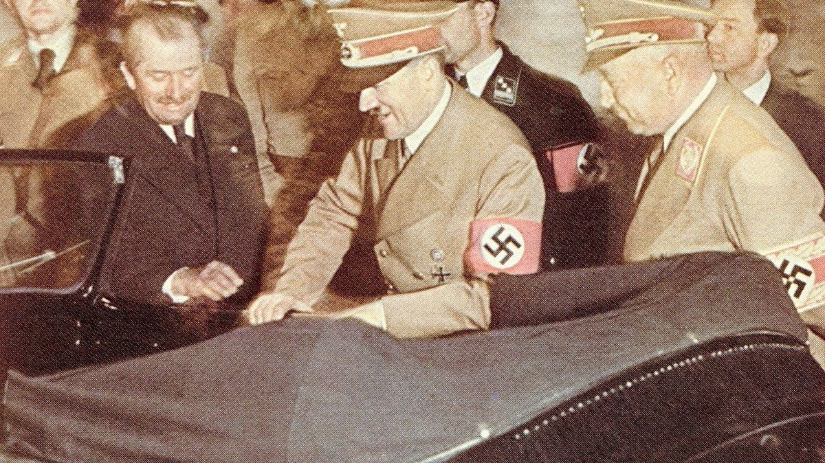 Vlevo Porsche a vedle něj Adolf Hitler nadšený jako malé dítě z nového Käfera (brouka). Dostal ho k narozeninám. Je příznačné, že na fotkách s Porschem a auty se Hitler často usmívá, což jinak nedělal. 