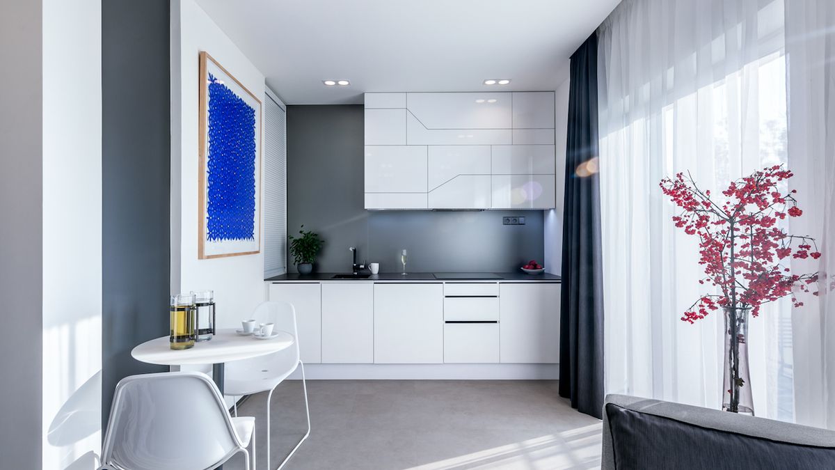 Interiér miniaturního bytu je laděn do příjemných světlých tónů v kombinaci bílé a světle šedé barvy.