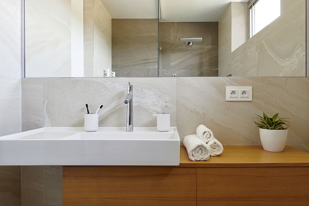 Koupelnu zdobí teplý nádech dýhy v koňakovém odstínu a krásná kresba mramorového obkladu.