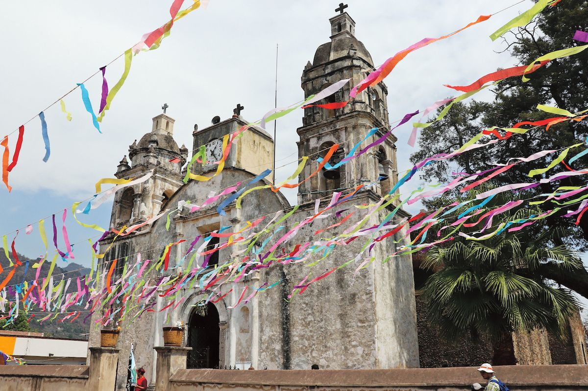 Kostel v městečku Tepoztlán s barevnými fáborky, které vlají nad celou ulicí.