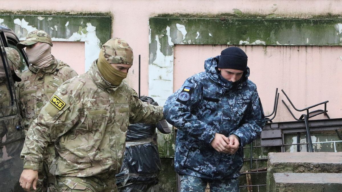 Příslušník ruské tajné služby FSB odvání zadrženého ukrajinské námořníka k soudu. 