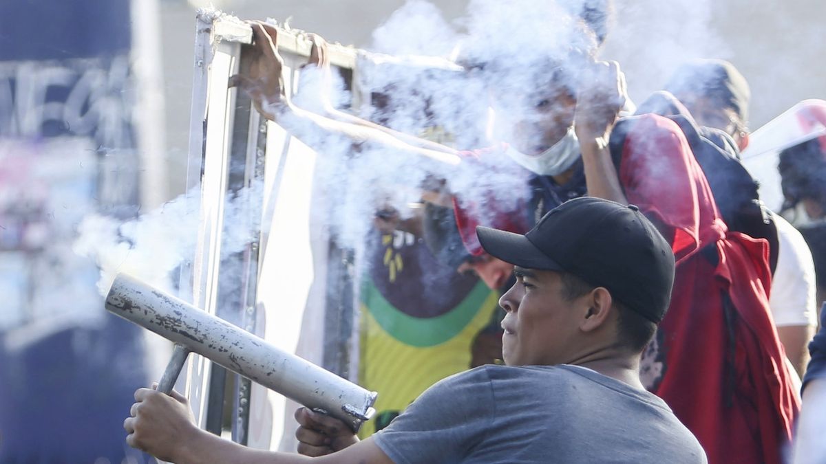 Nikaragujský demonstrant střílí na policisty z improvizovaného granátometu. 