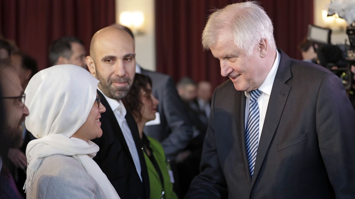 Německý ministr vnitra Horst Seehofer si potřásá rukou s účastnicí konference k islámu.