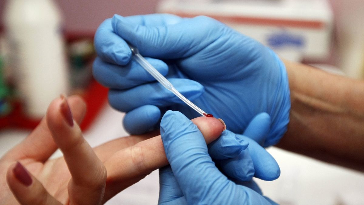 Odběr kapky krve z prstu pro testování na HIV. 