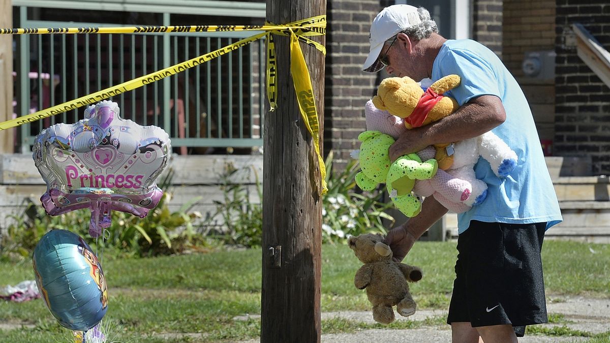 Muž přináší hračky k domu, kde ve městě Erie zahynulo pět dětí.