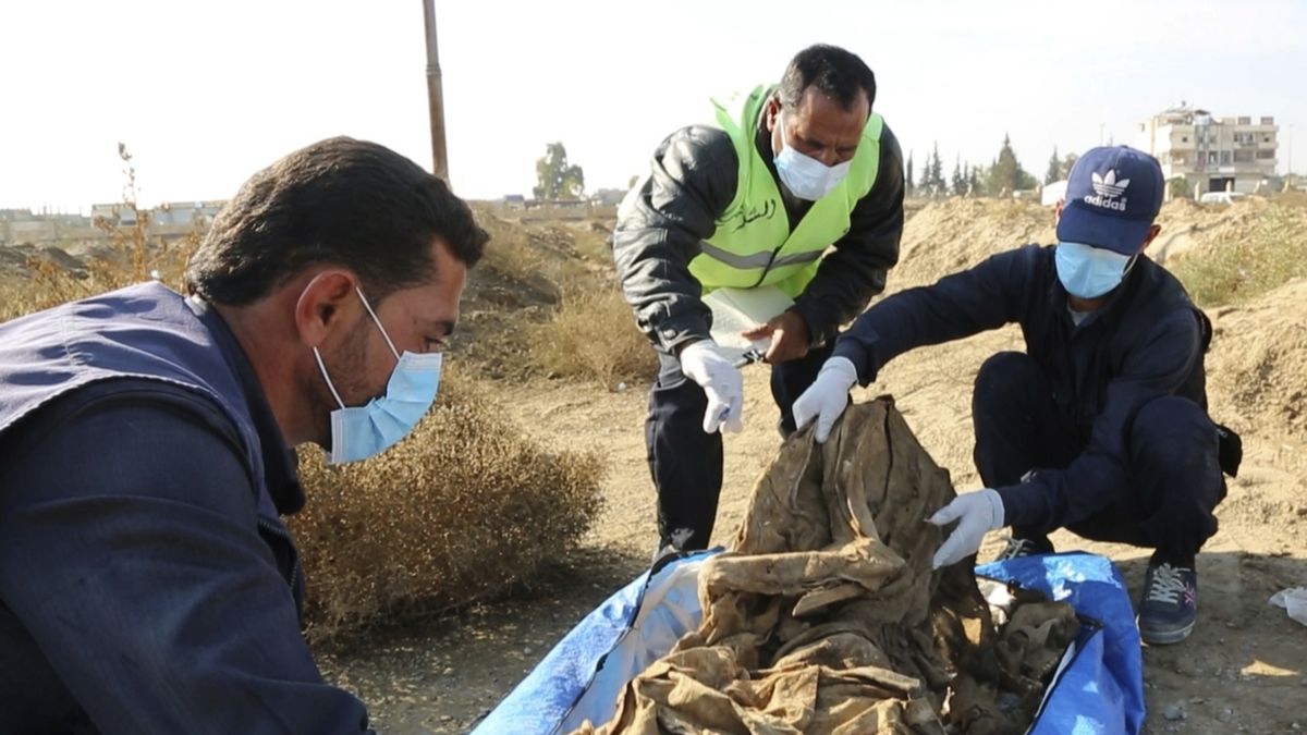 Tělo vyzvednuté z masového hrobu u Rakky e city. (AP Photo)