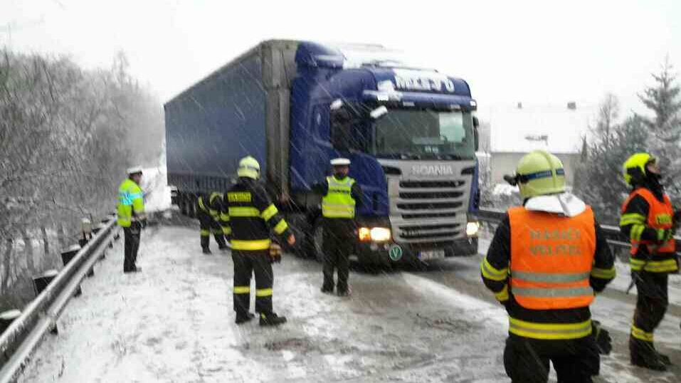 Na Blanensku ve stoupání silnice 43 u obce Závist mají problémy kamiony. Jednomu z nich právě pomáhají hasiči.