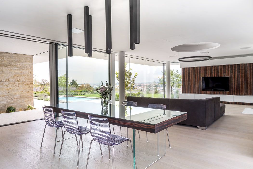 Jídelní stůl na skleněné podnoži je analogií architektonického konceptu levitující desky. Obě sériově vyráběná osvětlovací tělesa jsou zajímavě zakomponována do sádrokartonových podhledů a vytvářejí originální solitéry.