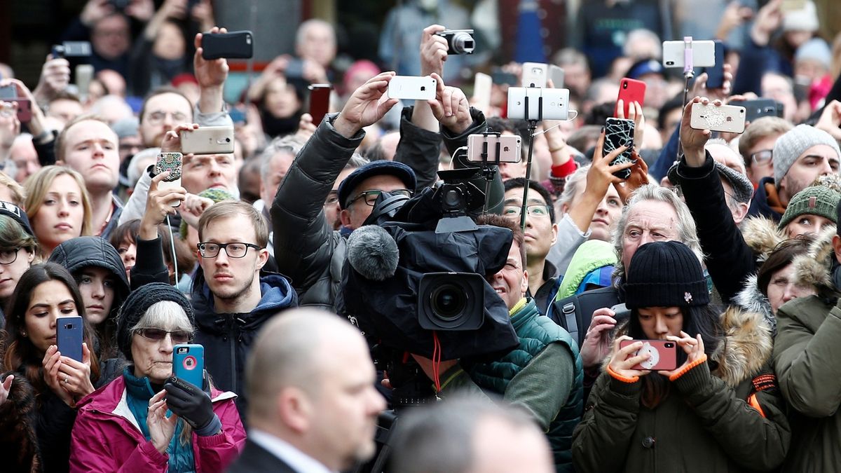 Members of the public and media photograph the funeral cortege as it arrives at Great St Marys Church, where the funeral of theoretical physicist Prof Stephen Hawking is being held.