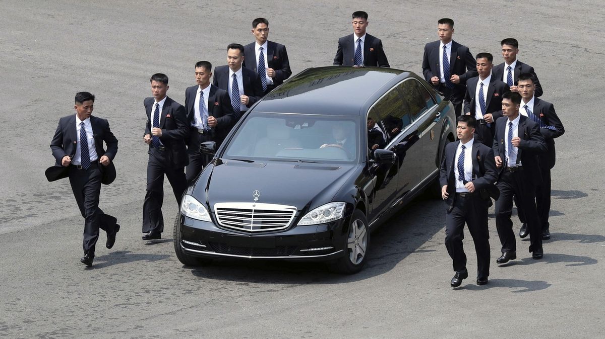 Příslušníci severokorejské ochranky běží vedle mercedesu, jímž jede Kim Čong-un.