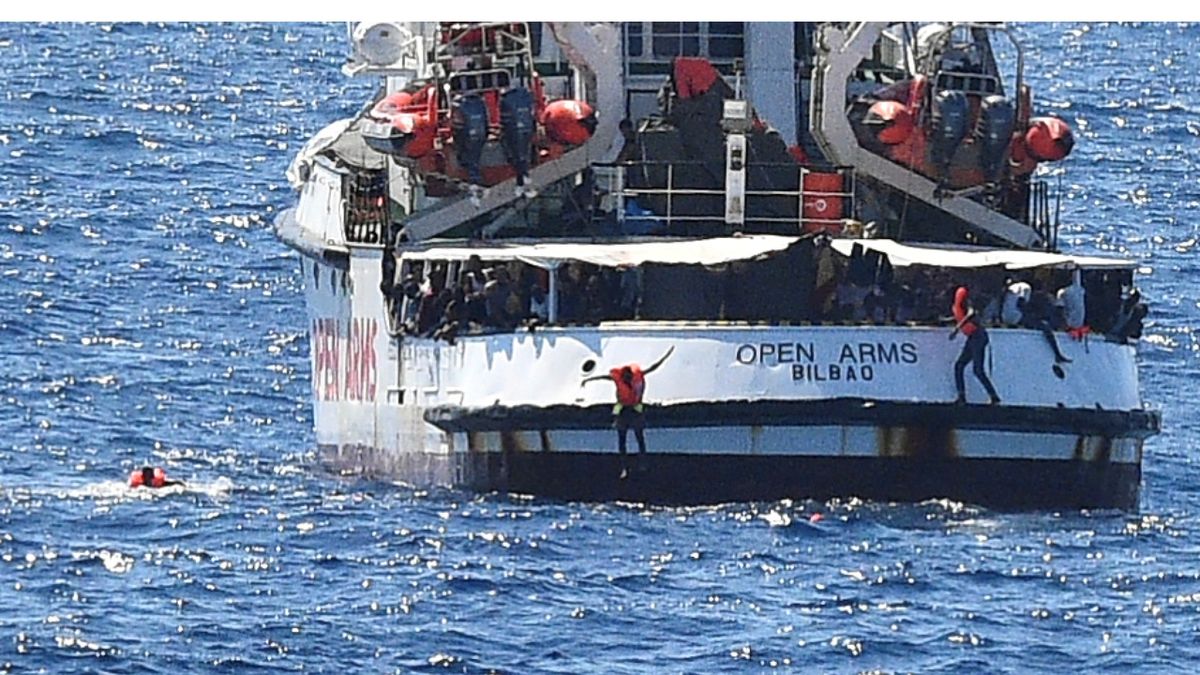 Migranti skáčou do moře z paluby španělské záchranné lodě Open Arms, aby doplavali k italskému ostrovu Lampedusa