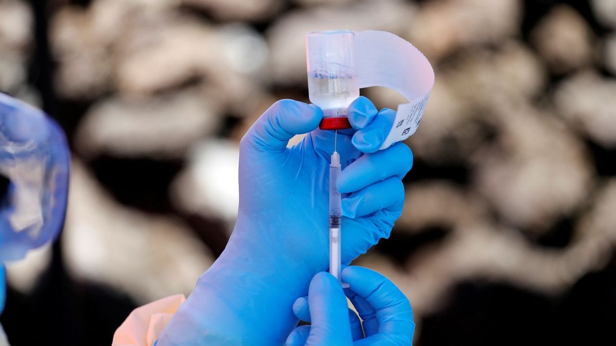 Zdravotník natahuje do stříkačky lék s protilátkou proti ebole.  