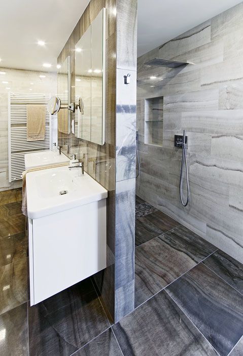 Koupelna v patře je rozdělena příčkou na umyvadlovou část a sprchový kout, kde je dost místa pro sprchování ve dvou. Nábytková sestava je na míru, z lakovaných MDF desek, hladký bílý povrch vynikne na pozadí italského obkladu a dlažby.