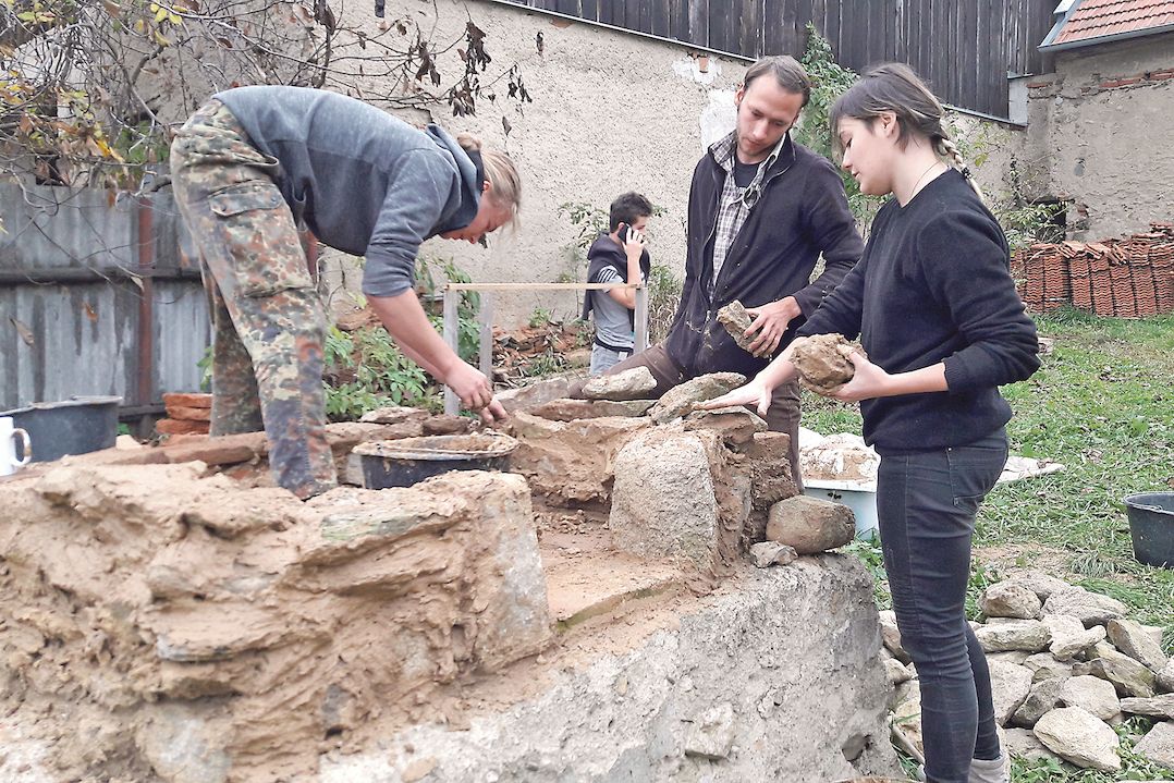 Studenti staví na zahradě výzkumné stanice chlebovou pec, významný objev z letošního léta. Je třeba ověřit její funkčnost.