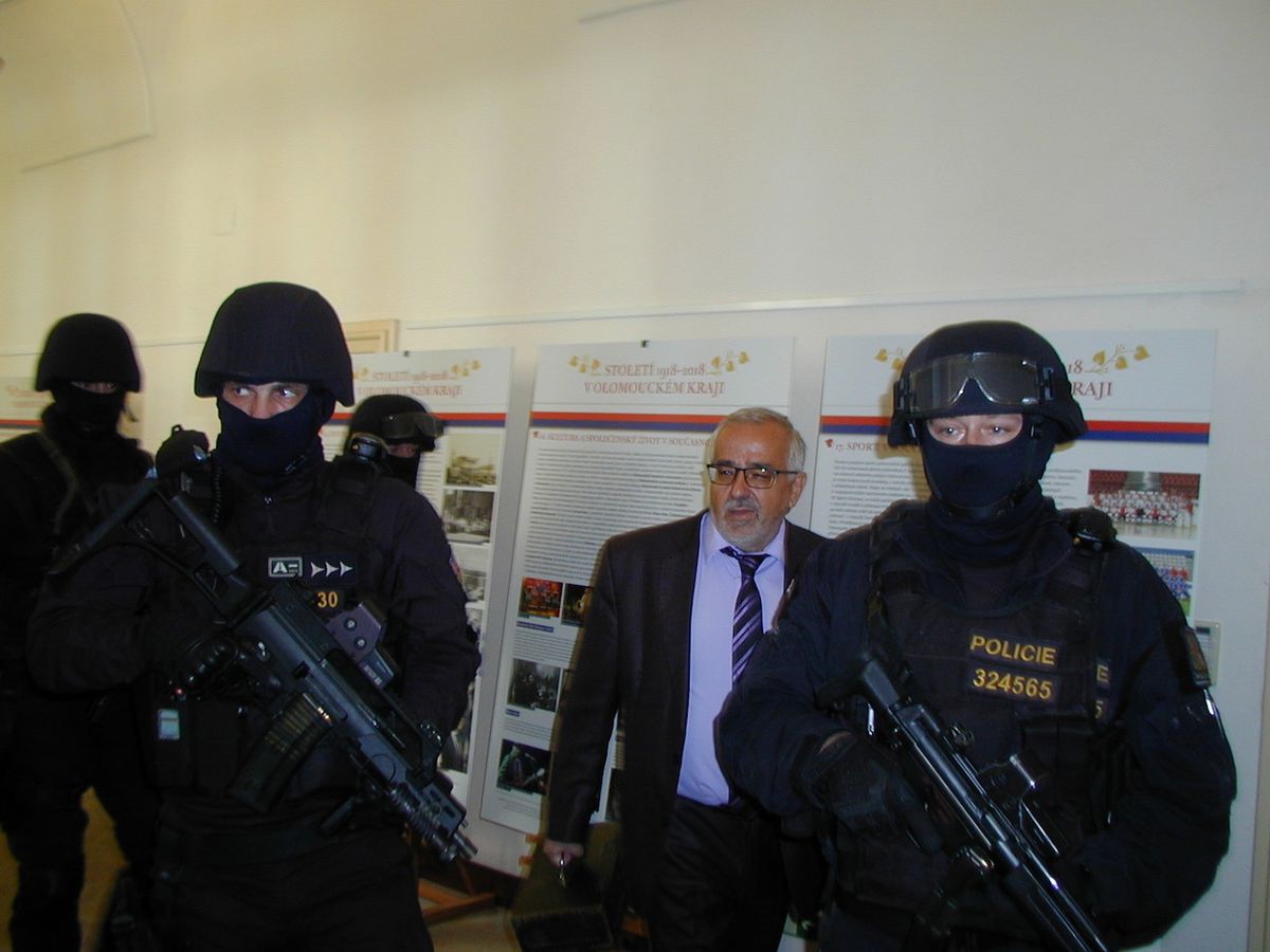 Ozbrojenci doprovázejí ředitele Vlastivědného muzea v Olomouci Břetislava Holáska, který přenáší vzácné bankovky.