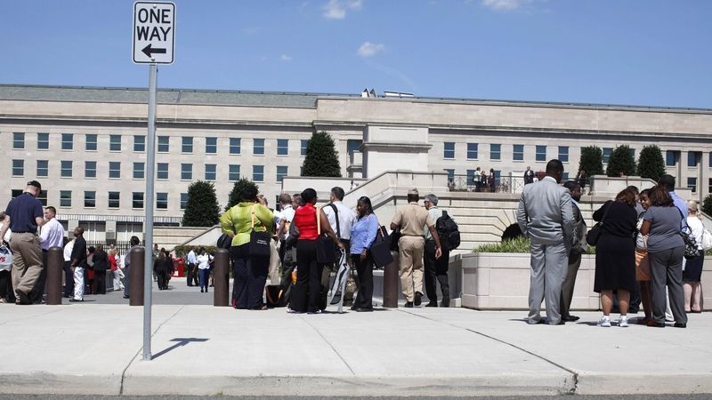 Lidé stojí před budovou Pentagonu.