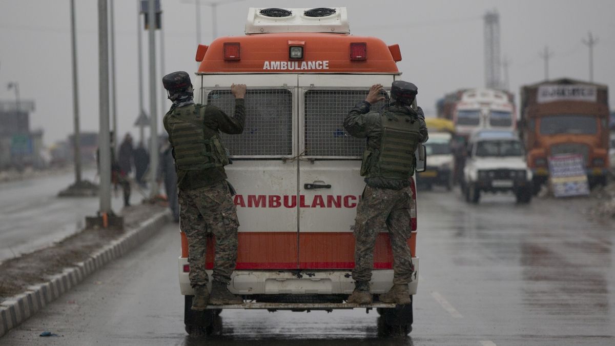 Indičtí policisté doprovázejí sanitku  