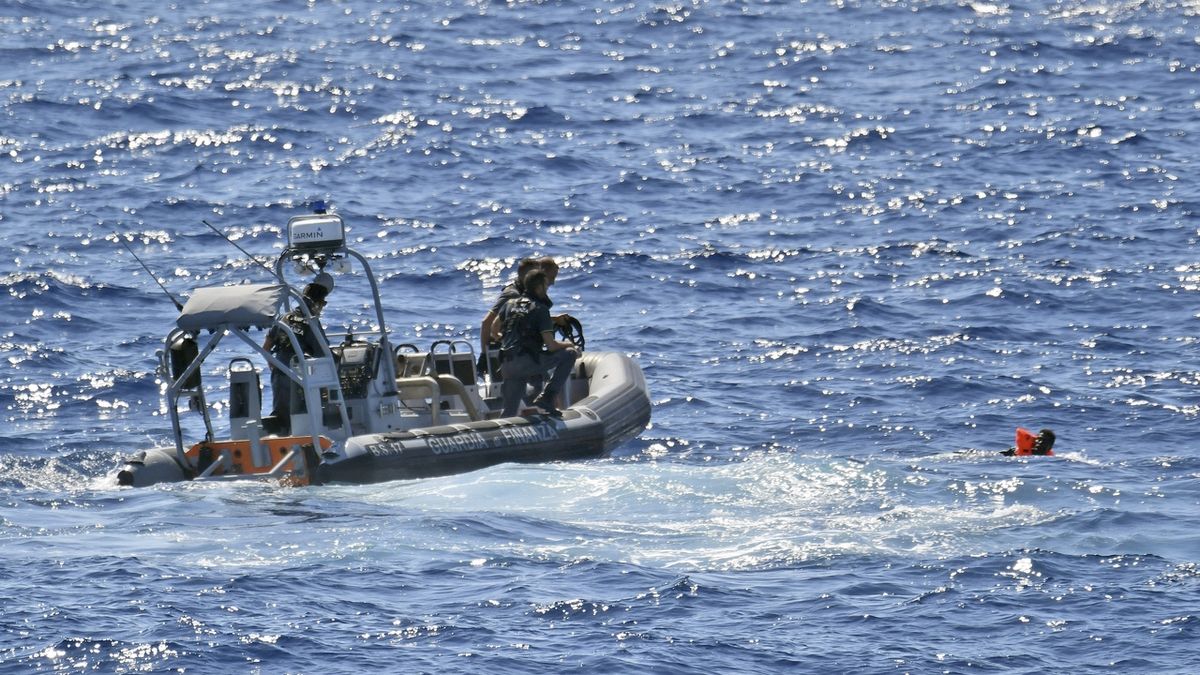 Italská pobřežní stráž zachraňuje migranty, kteří skočili do moře z paluby španělské záchranné lodě Open Arms, aby doplavali k italskému ostrovu Lampedusa