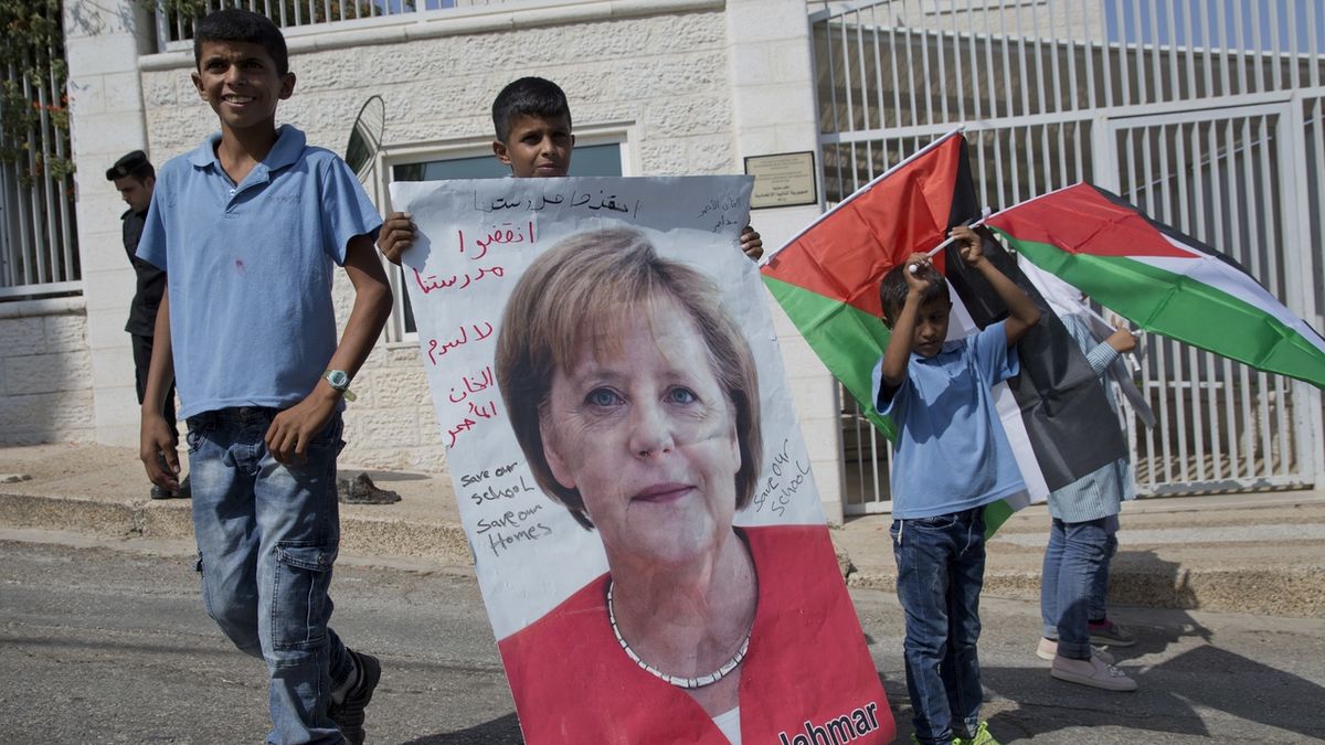 Děti z beduínské vesnice s portrétem Angely Merkelové