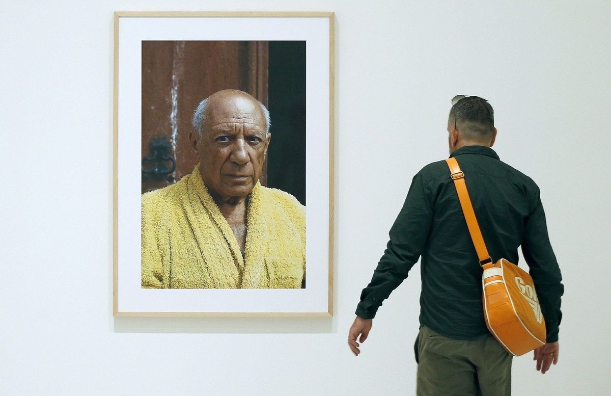 Muž si prohlíží portrét Pabla Picassa, který vyfotil David Douglas Duncan.