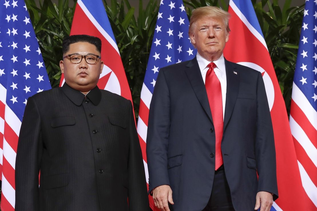Donald Trump a Kim Čong-un společně pózují před novináři.